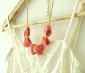 Three crochet bows necklace. Coral pink, golden chain.
