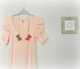 Opposites attract. Crochet bow necklace. Coral pink and sand.