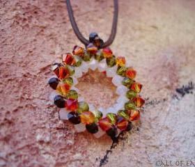 Beadwoven round pendant tangerine green burgundy white swarovski crystals. Tribal influence.