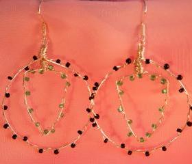 Wire hooped earrings with seed beads. hooped outer and shield shaped inner, opaque black and matt green seed beads. handmade.
