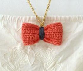 Crochet bow pendant. Salmon pink and grey cotton yarn.
