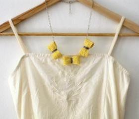 Three crochet bows necklace. Pale yellow and grey cotton yarn.