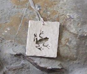Silver Frog Pendant: A textured sterling silver pendant showing a silhouette of a hoppity frog.