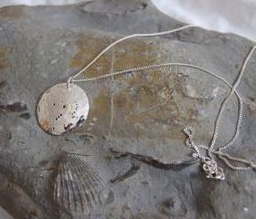 Silver Orion pendant: The constellation of Orion the hunter with his bow and arm on a domed sterling silver disc.
