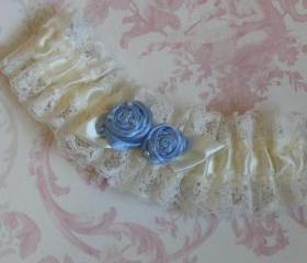 Ivory bridal garter with blue roses.